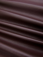 Close-up of dark brown ruched faux leather bodysuit, featuring diagonal folds and visible grain.