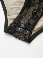 Black long-sleeve bodysuit with mesh panels, floral lace patterns, and crotch snap buttons.