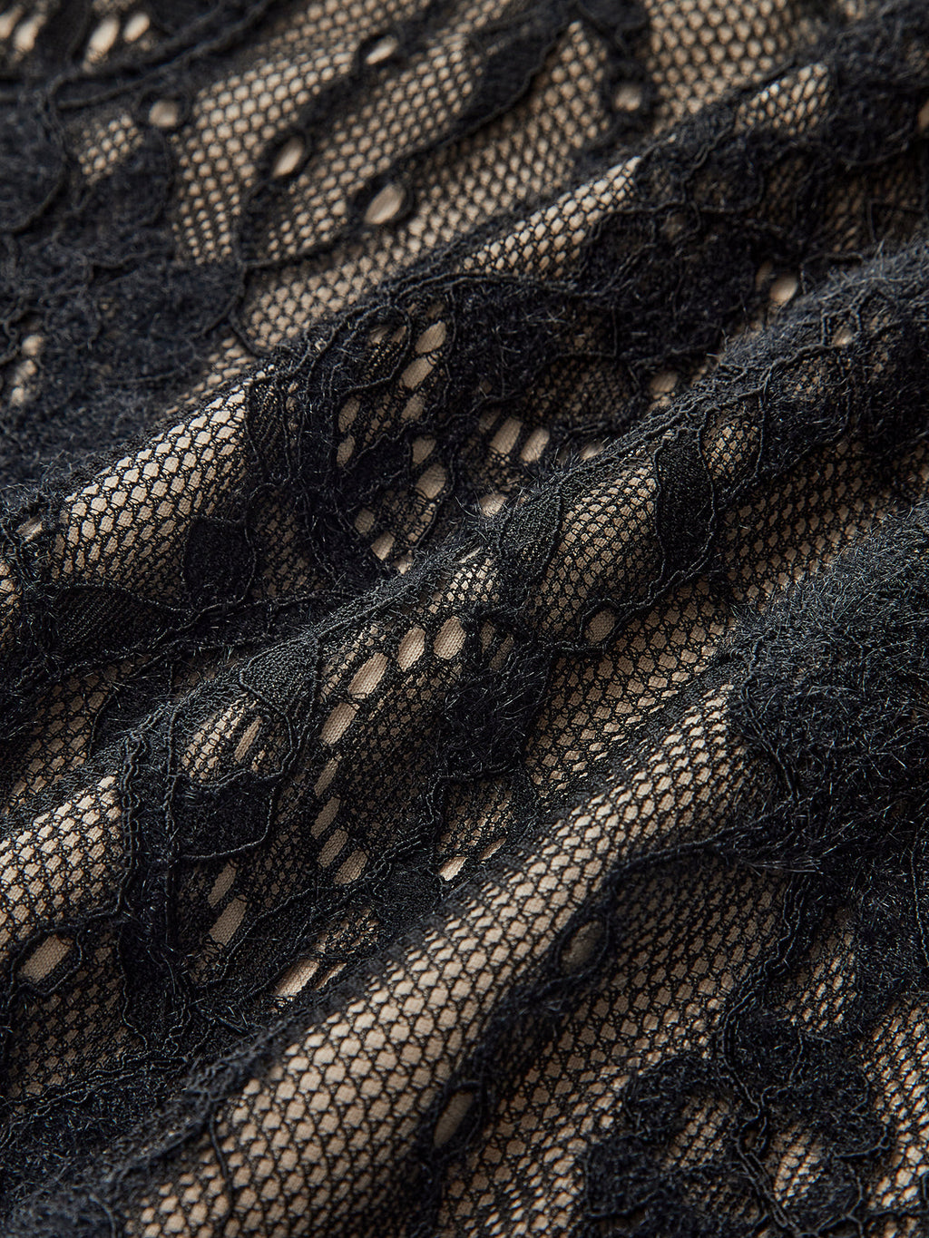 Elegant backless cami bodysuit with black floral lace over beige and delicate embroidered details.