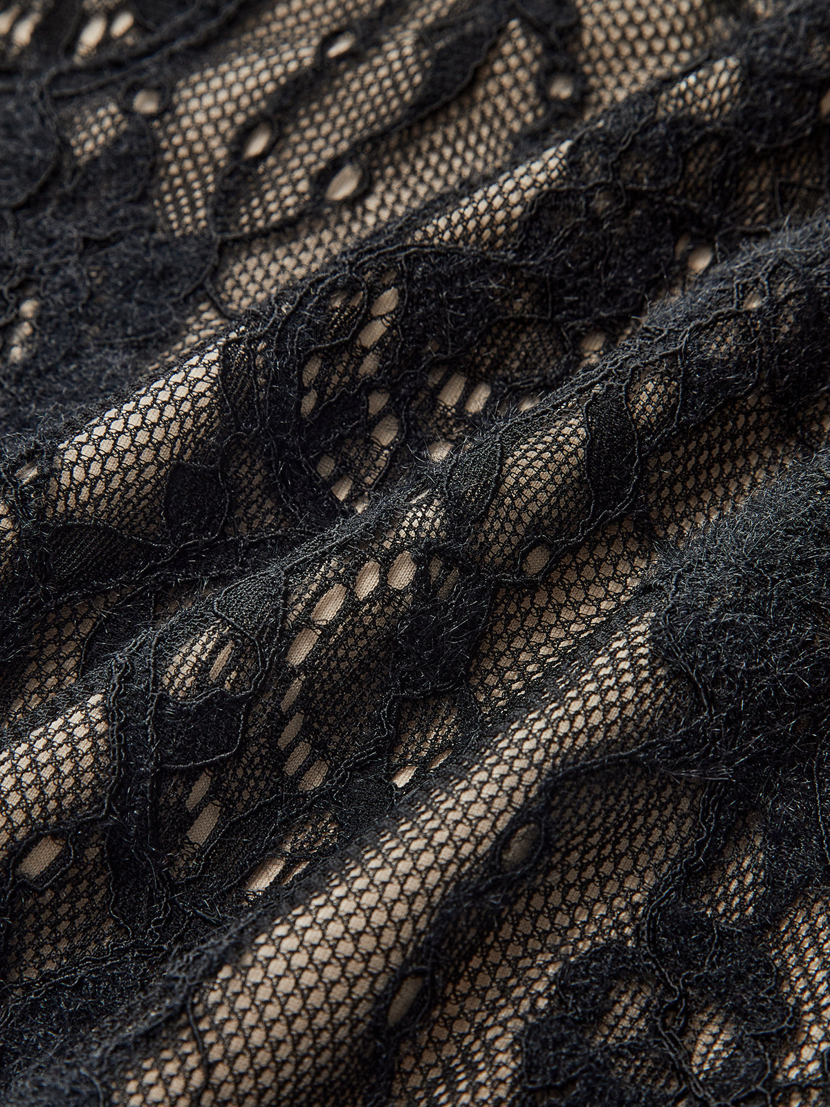 Elegant backless cami bodysuit with black floral lace over beige and delicate embroidered details.