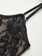Black lace and mesh backless cami bodysuit with floral details and delicate double straps.