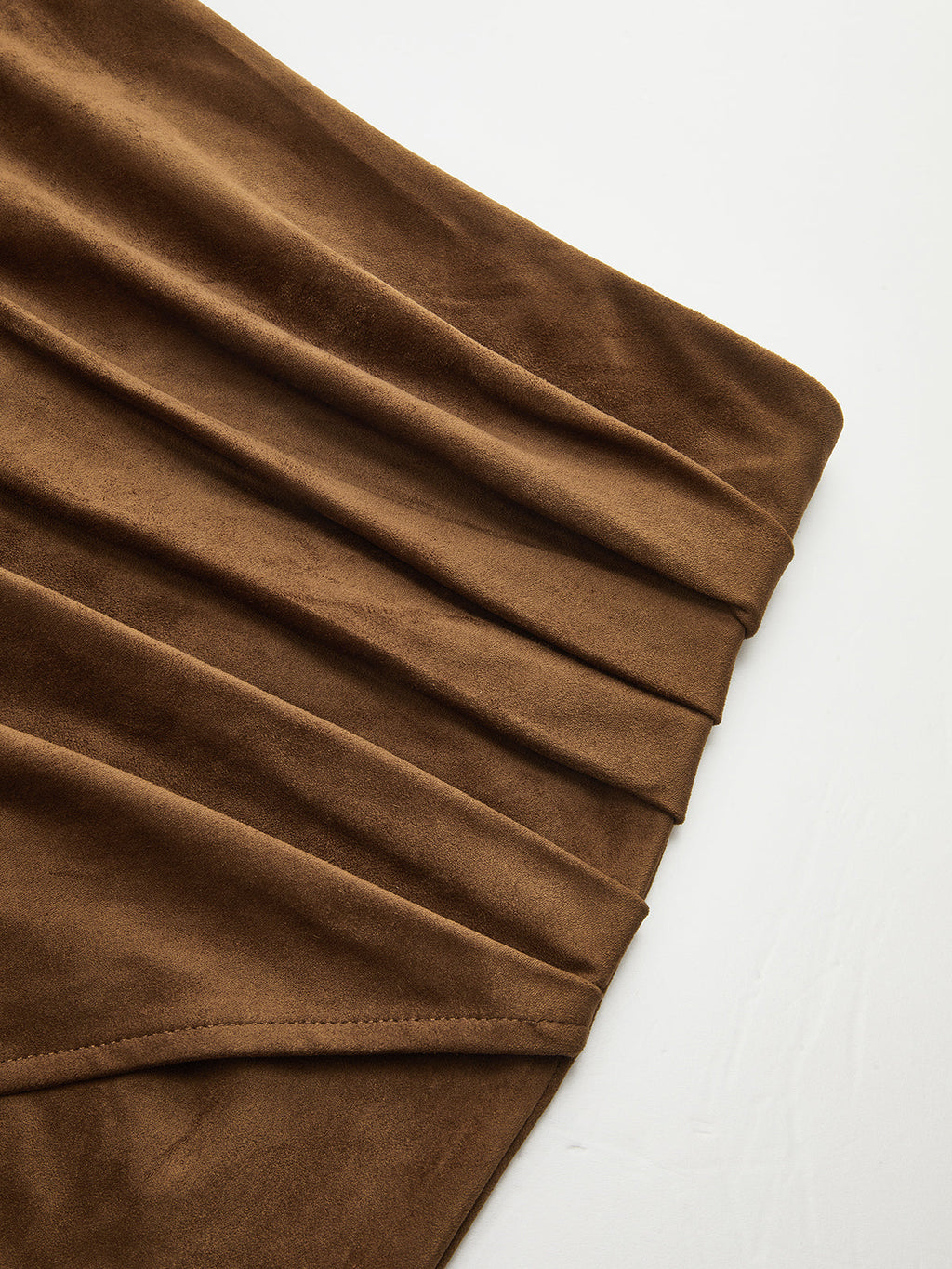 Brown suede midi skirt with leather trim, waist tie, subtle pleating, and matte texture.