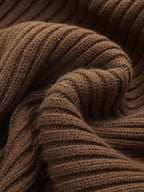 Soft brown cable-knit cropped sweater layered over a ribbed cami dress, highlighting cozy texture.