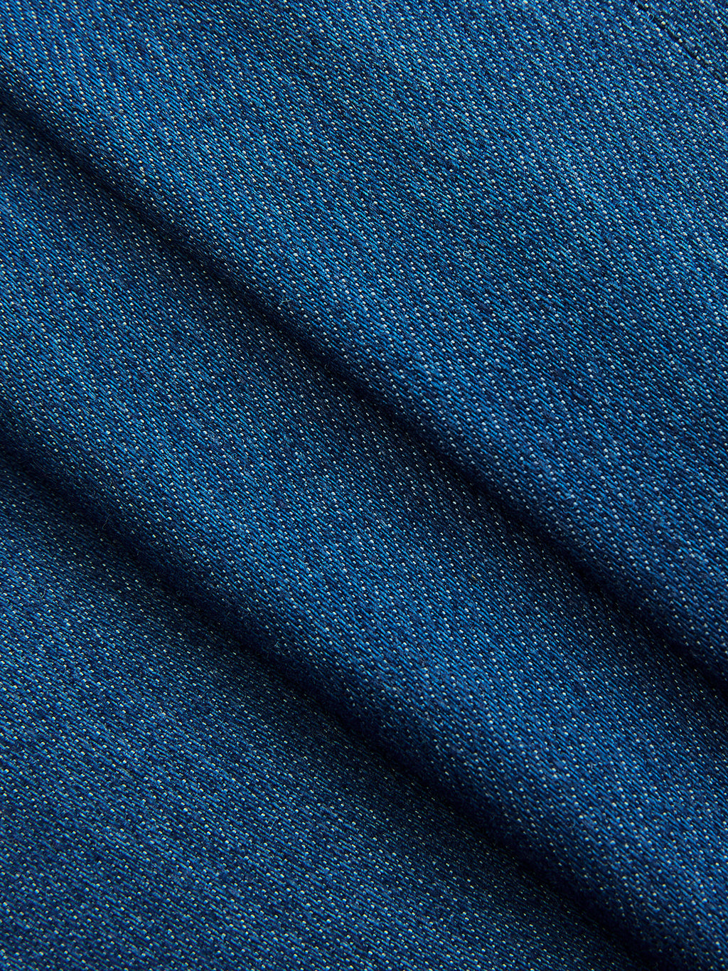 Blue denim wrap vest with a diagonal weave, adjustable tie waist, and soft textured folds.