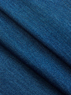 Blue denim wrap vest with a diagonal weave, adjustable tie waist, and soft textured folds.