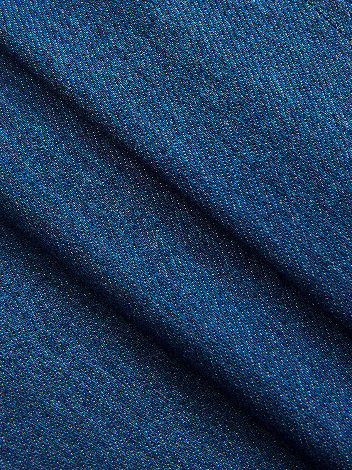 Blue denim wrap vest with a diagonal weave, adjustable tie waist, and soft textured folds.