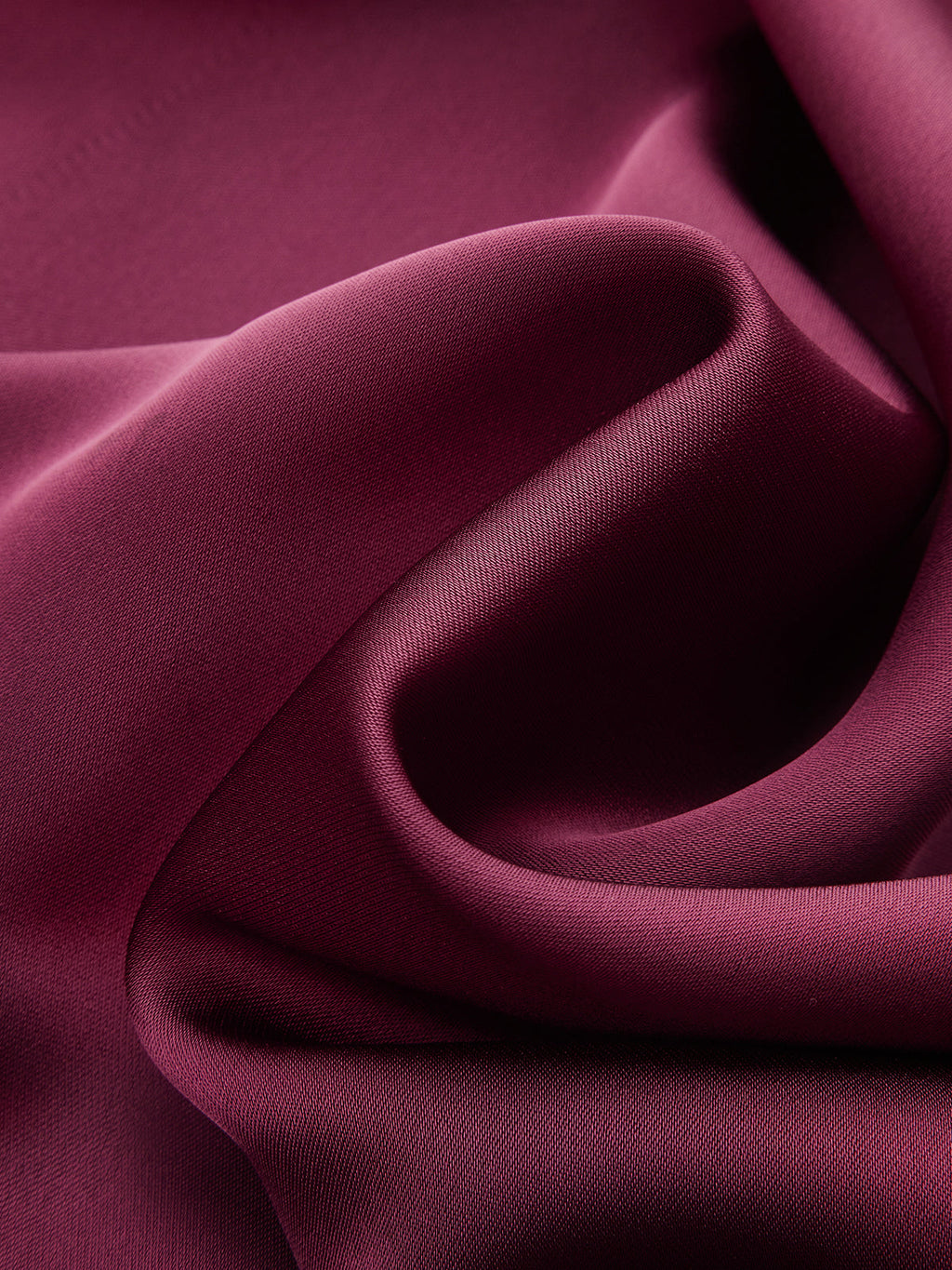 A satin mock neck blouse with an elegant neck tie, lustrous sheen, and soft curves.