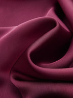 A satin mock neck blouse with an elegant neck tie, lustrous sheen, and soft curves.