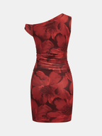 Asymmetrical mini dress with bold red floral print on dark mesh, ruched waist and hips.