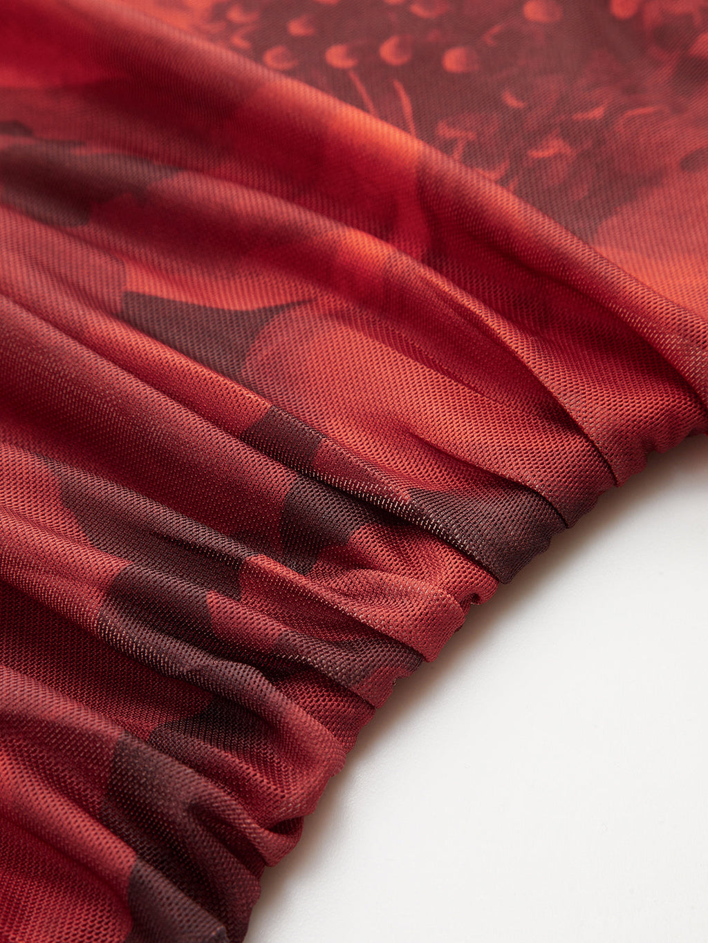 Ruched red and black mesh mini dress with printed pattern and gathered elastic seam.