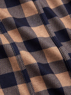 Plaid wide-leg jumpsuit with belted cami top, brown and navy woven fabric, diagonal seams.