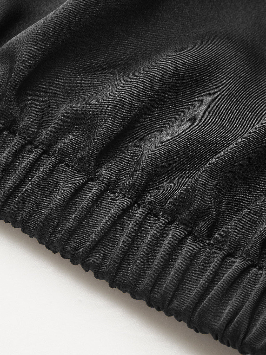 Black, shiny ruched satin blouse with cowl neck and elastic waistband detailing.