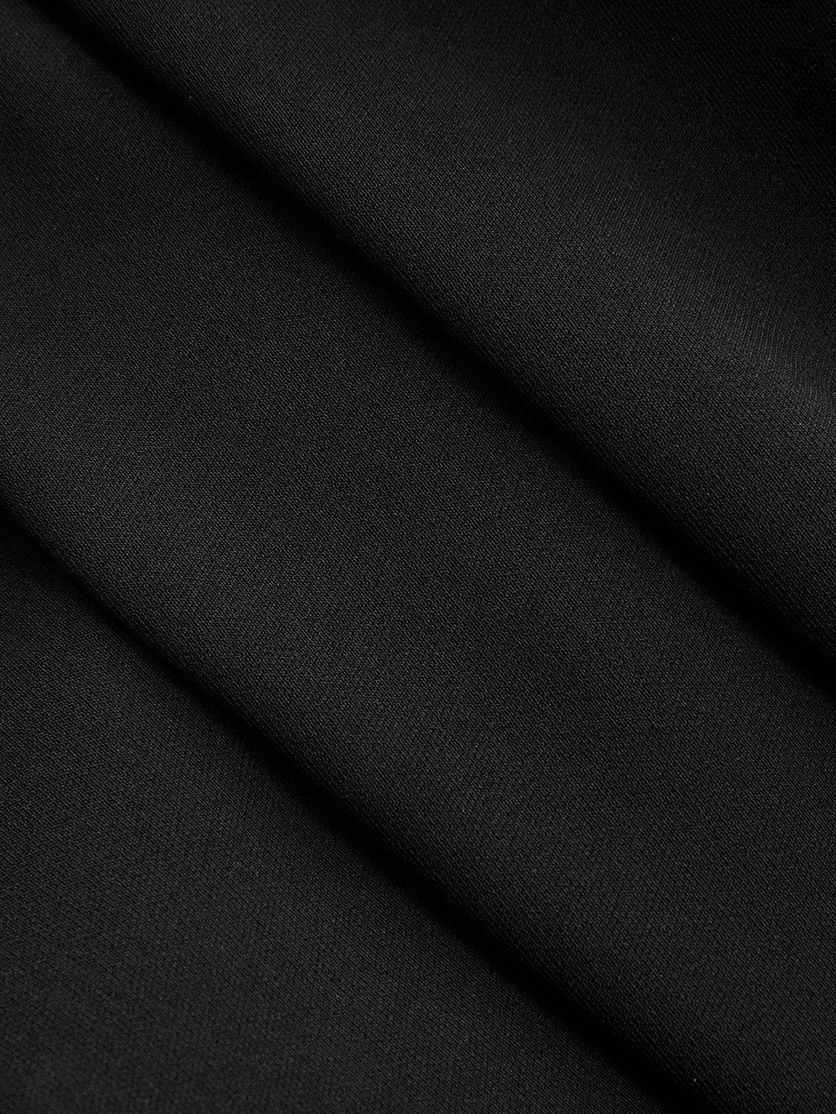 Close-up of black sleeveless blouse with collar, showing fine texture and soft diagonal folds.