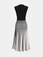A sleeveless midi dress with a fitted black top and flared white striped skirt.
