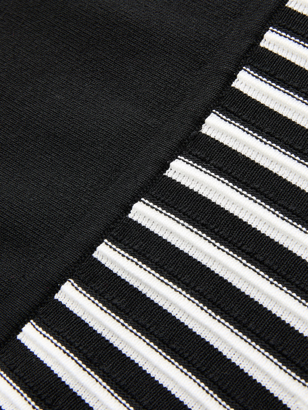Sleeveless mock neck midi dress with split black and striped panels, stretch-knit texture.