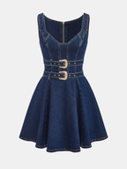 Denim mini dress with fitted bodice, flared skirt, dual buckles, and exposed back zipper.
