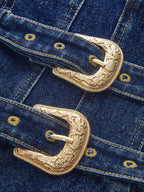 Denim mini dress with ornate gold dual buckles, yellow stitching, and metal rivet detailing.