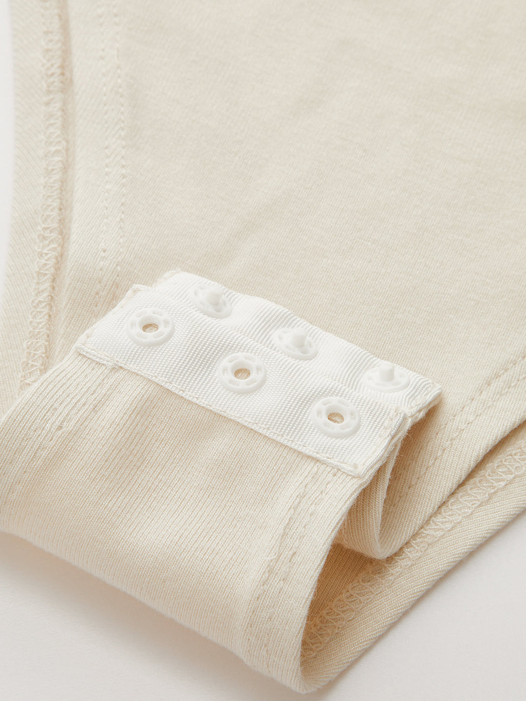 Metallic accent ruched bodysuit with mock neck, textured fabric, and intricate stitching details.