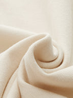 Soft cream-colored knit bodysuit with metallic accents, ruched details, and a mock neck.