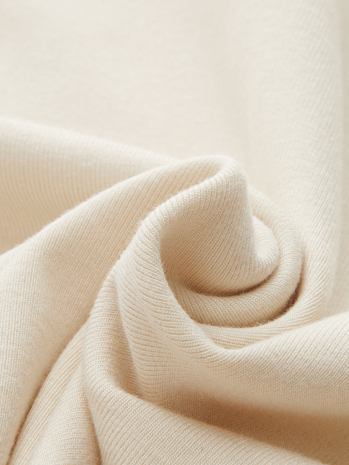 Soft cream-colored knit bodysuit with metallic accents, ruched details, and a mock neck.