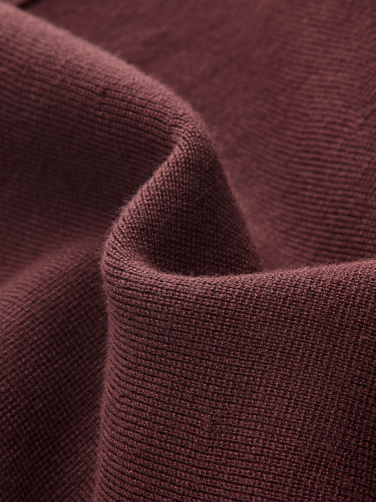 Dark red, ribbed knit mini dress with soft folds and a subtly fuzzy texture.