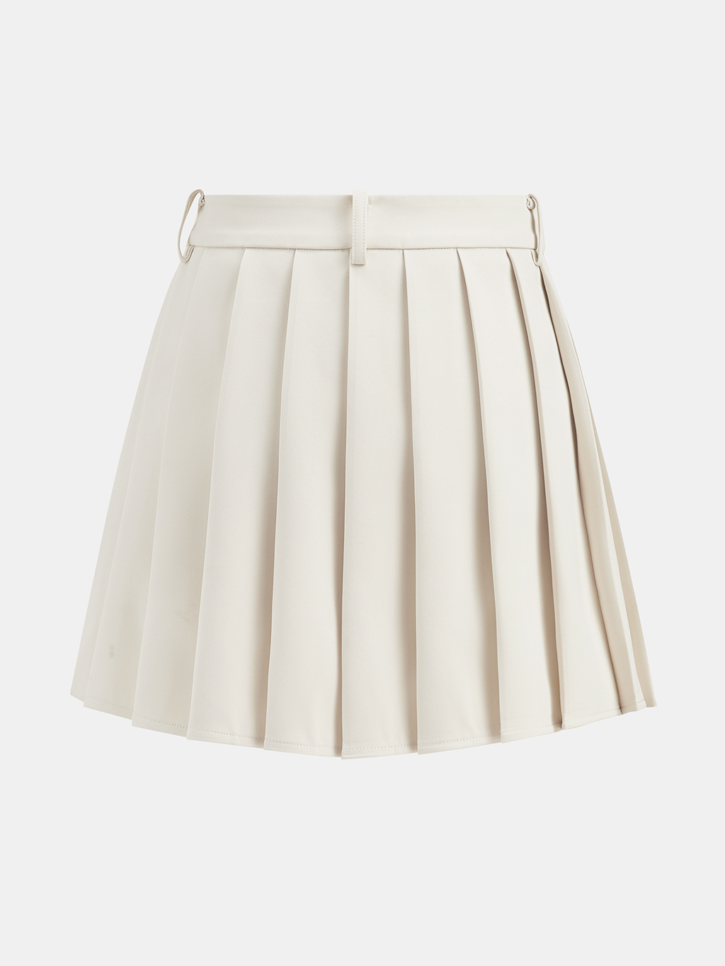 Cream belted vest paired with a pleated mini skirt featuring metal rings and loops.