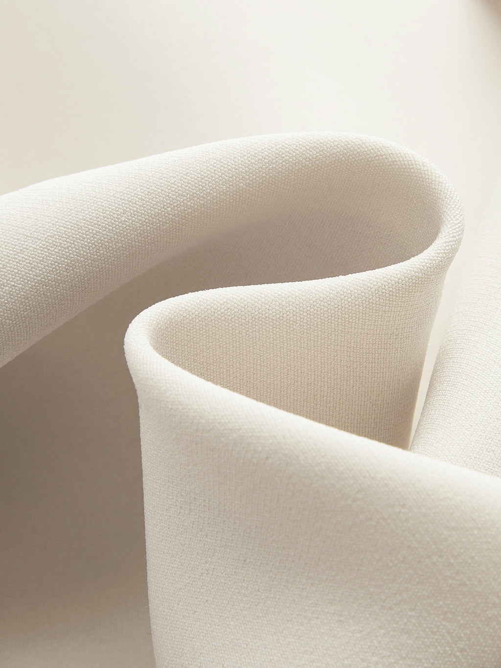 A cream belted vest and pleated skirt set with softly folded draping and curves.