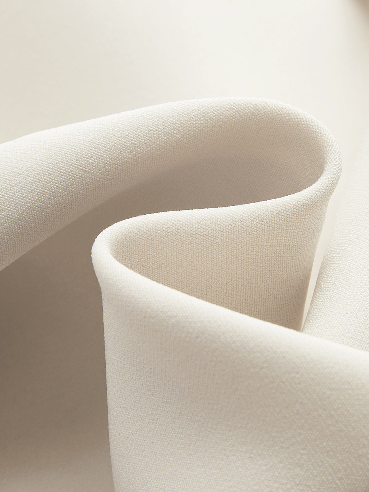 A cream belted vest and pleated skirt set with softly folded draping and curves.