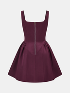 A sleeveless deep burgundy satin mini dress with square neckline, fitted bodice, flared skirt.