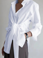 A white semi-sheer long shirt with button-down ties, open collar, and long sleeves.