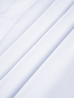 Semi-sheer long shirt with button-down ties, smooth white fabric and soft folds.