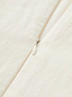 Sleeveless Tencel blend mini dress with fine vertical texture, asymmetric buckle, and ruched detailing.