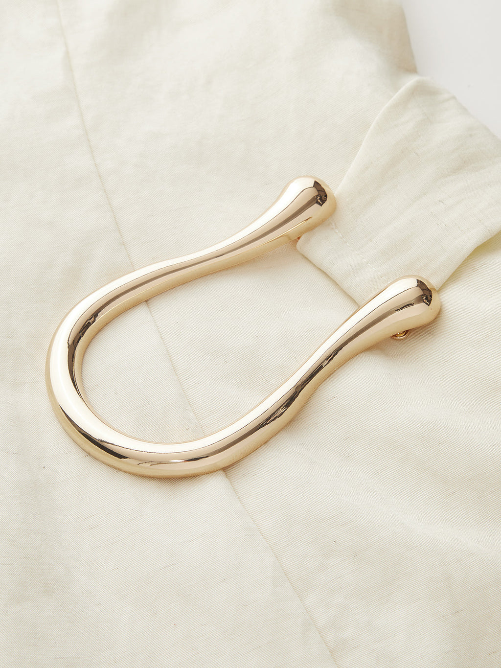 A cream-colored LA FINE FLEUR Tencel Blend mini dress with asymmetric buckle ruching.