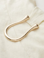 A cream-colored LA FINE FLEUR Tencel Blend mini dress with asymmetric buckle ruching.