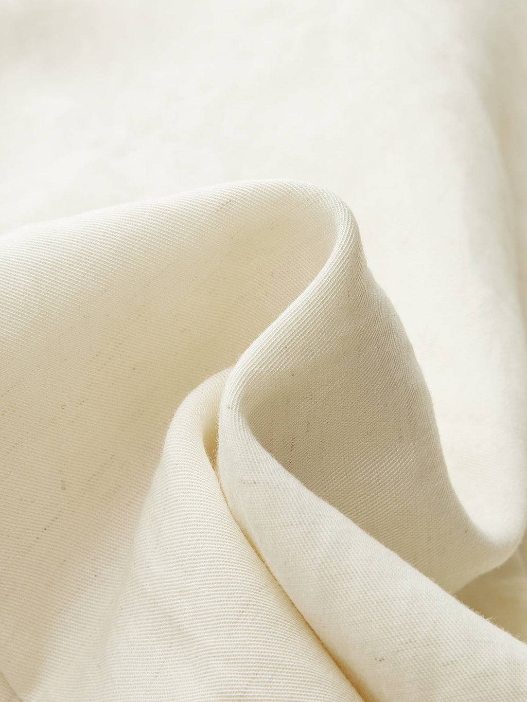 Soft, off-white Tencel Blend mini dress with asymmetric buckle ruching and textured folds.