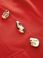 Vibrant red sleeveless blazer vest with three irregular gold sculptural buttons and structured silhouette.
