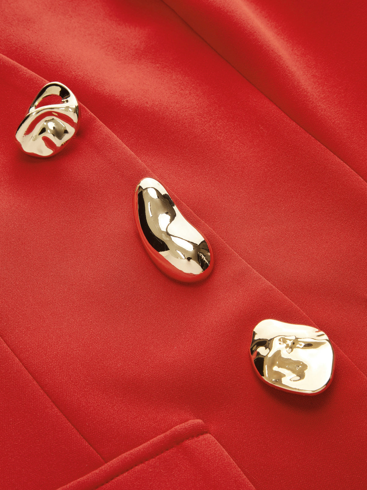 Vibrant red sleeveless blazer vest with three irregular gold sculptural buttons and structured silhouette.