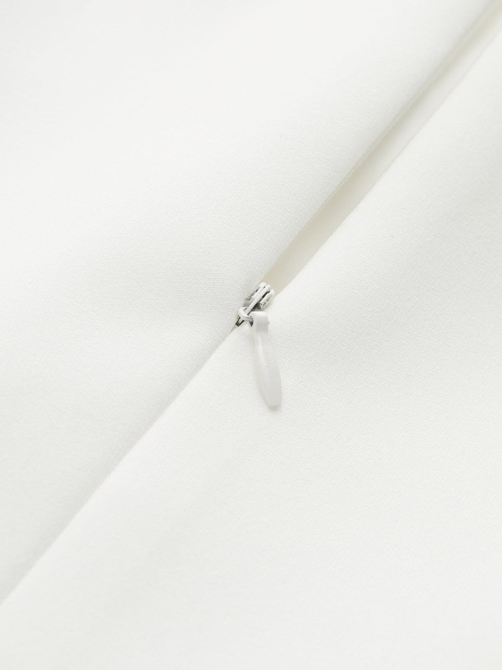 Silver zipper detail on smooth white LA FINE FLEUR pleated sleeveless mini dress.