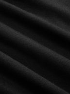 Close-up of black dress fabric showing diagonal ribs, soft folds, and fine textured lines.