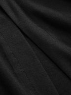 Close-up of LA FINE FLEUR black dress showing ruched sides, button details, seams, and folds.