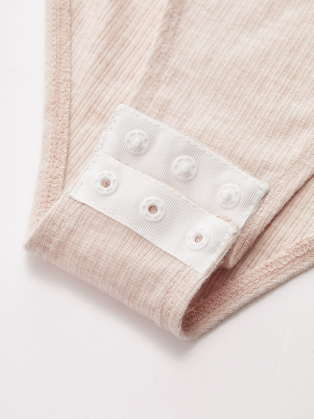 Ruched ribbed light pink square neck bodysuit with white snap button closure detailing.