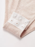 Ruched ribbed light pink square neck bodysuit with white snap button closure detailing.