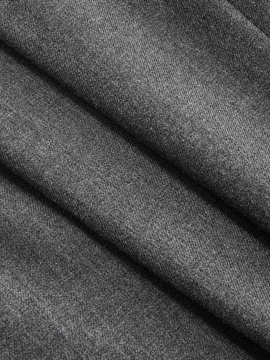 Soft grey sleeveless belted blazer dress, pleated details, subtle diagonal lines, refined woven texture.