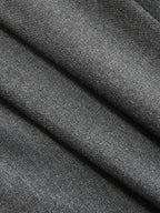 Soft grey sleeveless belted blazer dress, pleated details, subtle diagonal lines, refined woven texture.