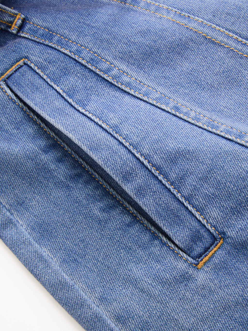 Sleeveless belted denim shirt dress with slanted front pocket, double stitching, and orange thread accents.