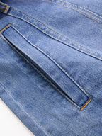 Sleeveless belted denim shirt dress with slanted front pocket, double stitching, and orange thread accents.