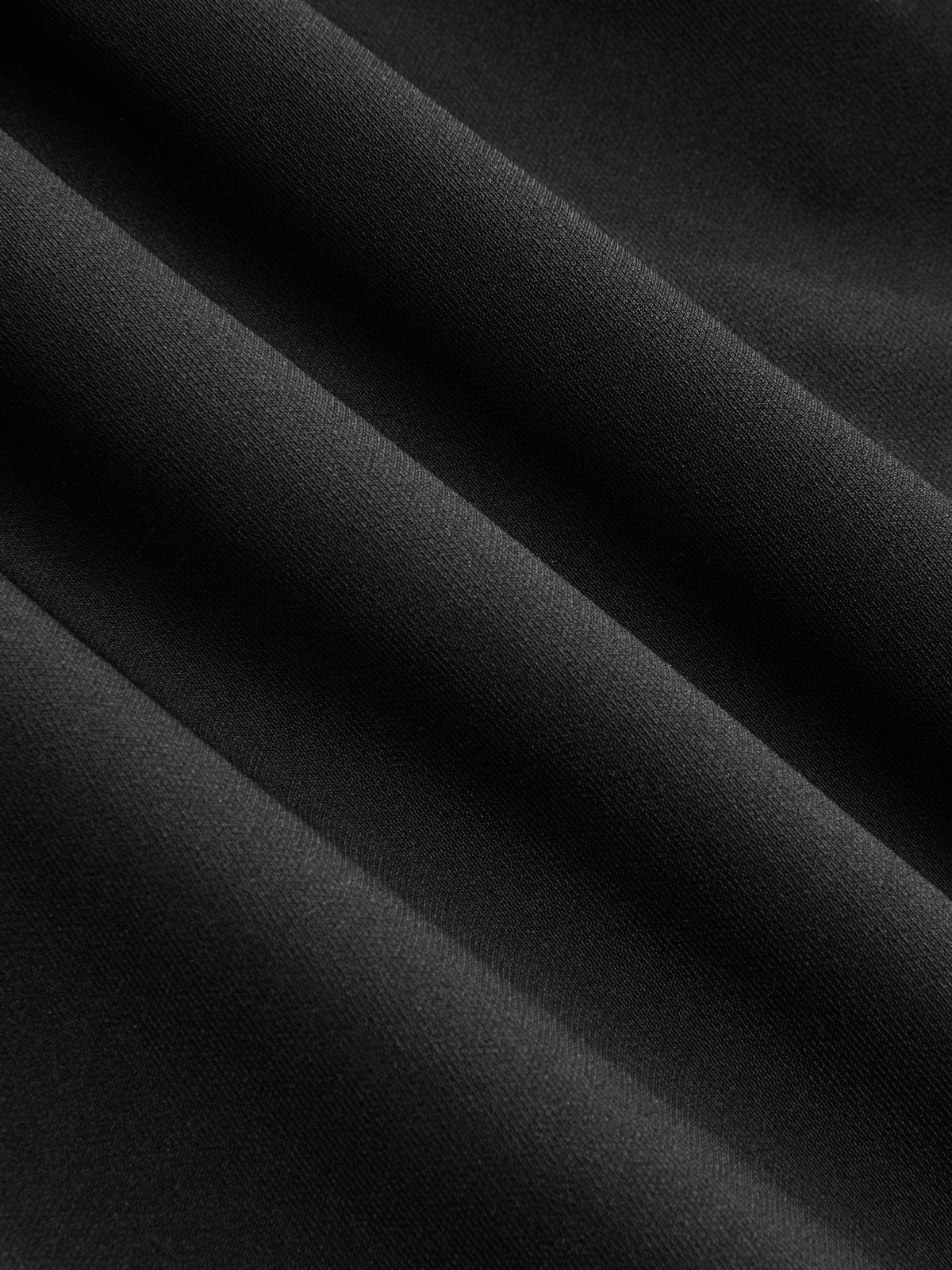 Black fabric dress with soft folds, subtle texture, button accents, and a flared hem.