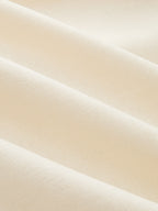 Close-up of a cream linen-blend wrap dress, highlighting textured weave and contrast trim.