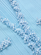 Light blue knit mini dress with pearl trim and a ruffled hem, textured detailing throughout.