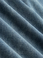 Blue denim wide-leg jeans with visible diagonal weave, featuring unique ruching and asymmetrical design.